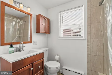 a bathroom with a sink vanity mirror and toilet