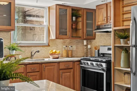 a kitchen with stainless steel appliances granite countertop a refrigerator and a sink