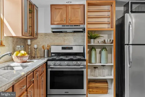 a kitchen with stainless steel appliances granite countertop a refrigerator stove and sink