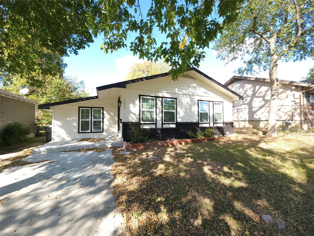 a front view of a house with a garden and yard