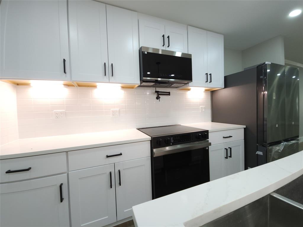 7039 Bates Street Dallas, TX 75227 - Photo 12 of 40 a kitchen with cabinets and steel stainless steel appliances