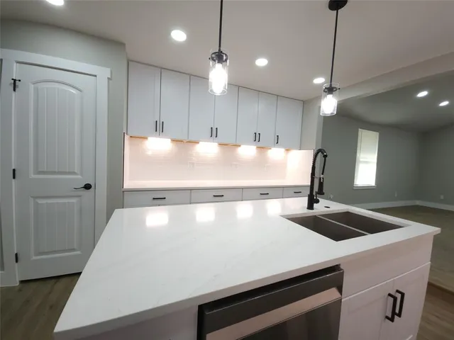 a large kitchen with granite countertop a stove a sink and a refrigerator