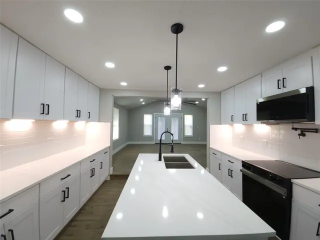 a large kitchen with kitchen island a sink stainless steel appliances and a counter top space