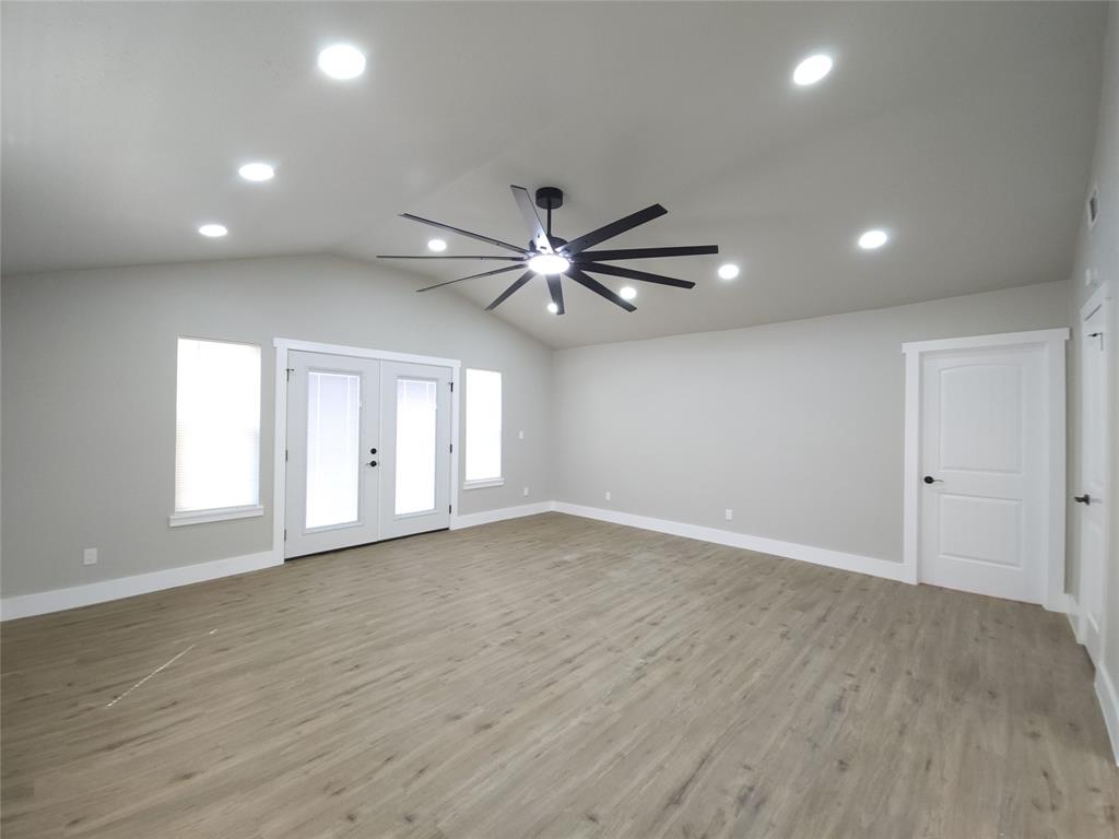 7039 Bates Street Dallas, TX 75227 - Photo 15 of 40 an empty room with wooden floor and windows