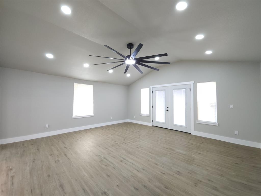 7039 Bates Street Dallas, TX 75227 - Photo 16 of 40 an empty room with wooden floor and windows