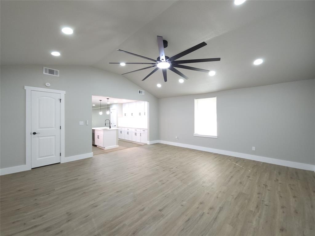 7039 Bates Street Dallas, TX 75227 - Photo 17 of 40 an empty room with wooden floor and windows