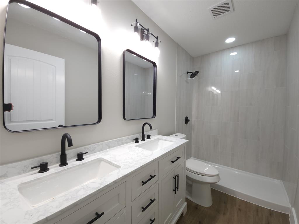 7039 Bates Street Dallas, TX 75227 - Photo 29 of 40 a bathroom with double vanity sinks and a mirror