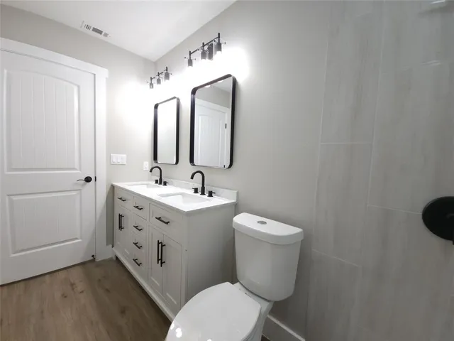 a bathroom with a toilet sink and mirror