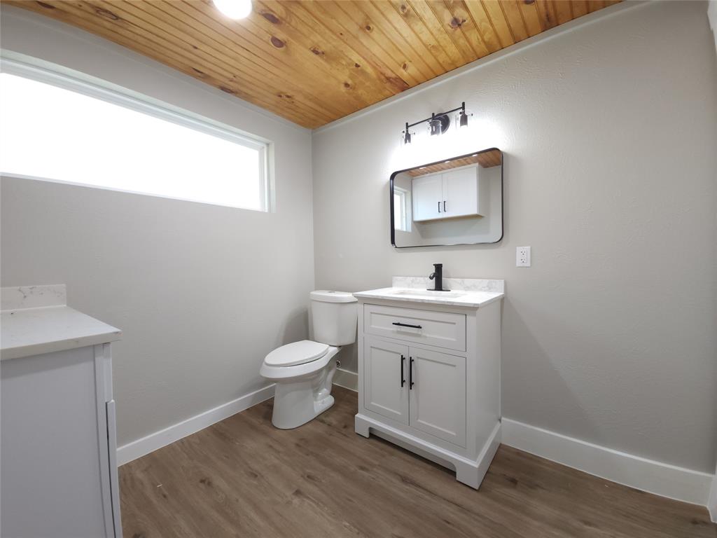 7039 Bates Street Dallas, TX 75227 - Photo 36 of 40 a bathroom with a toilet sink and mirror