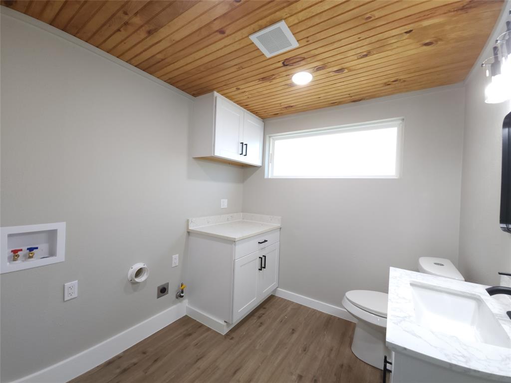 7039 Bates Street Dallas, TX 75227 - Photo 38 of 40 a bathroom with a toilet sink and mirror