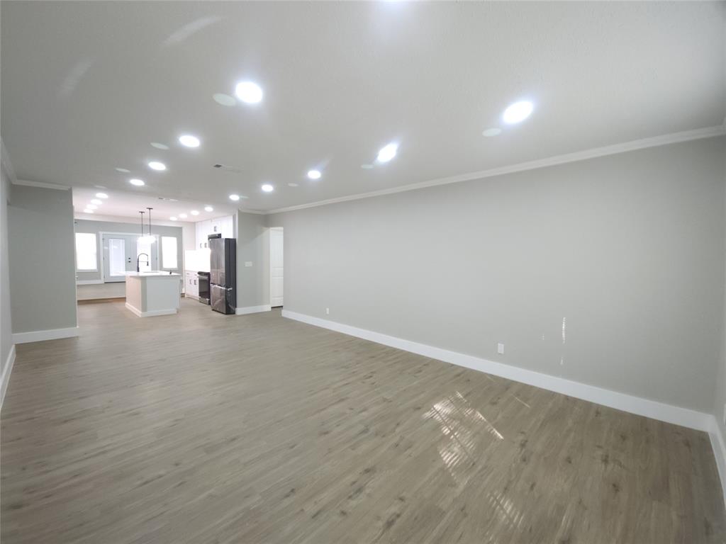 7039 Bates Street Dallas, TX 75227 - Photo 4 of 40 an empty room with a kitchen