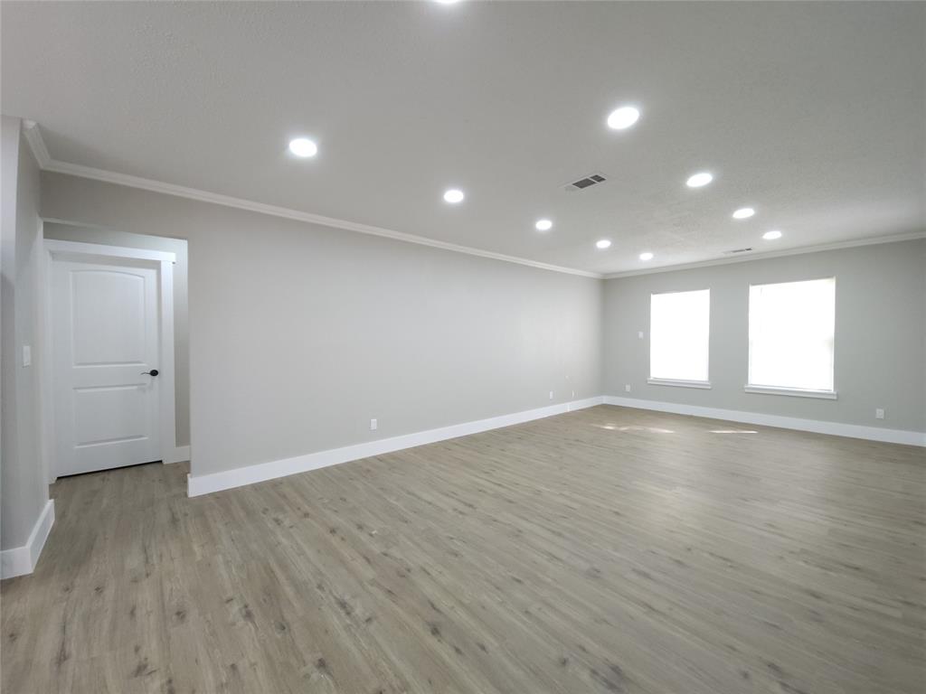 7039 Bates Street Dallas, TX 75227 - Photo 6 of 40 an empty room with wooden floor and windows