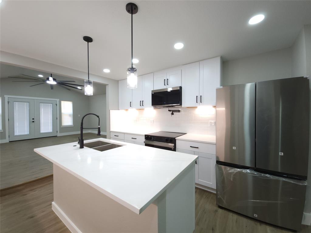 7039 Bates Street Dallas, TX 75227 - Photo 9 of 40 a kitchen with stainless steel appliances a refrigerator sink and microwave