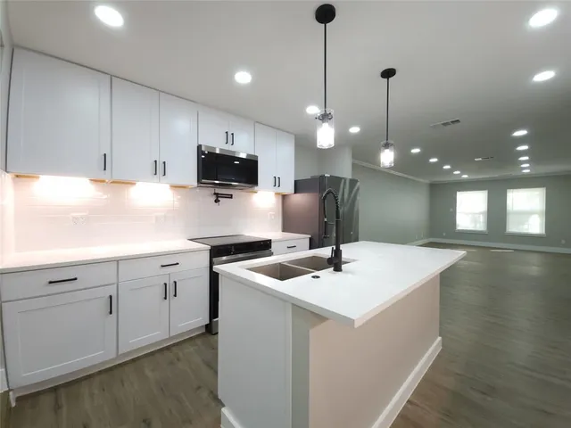 a kitchen with a sink stove and microwave