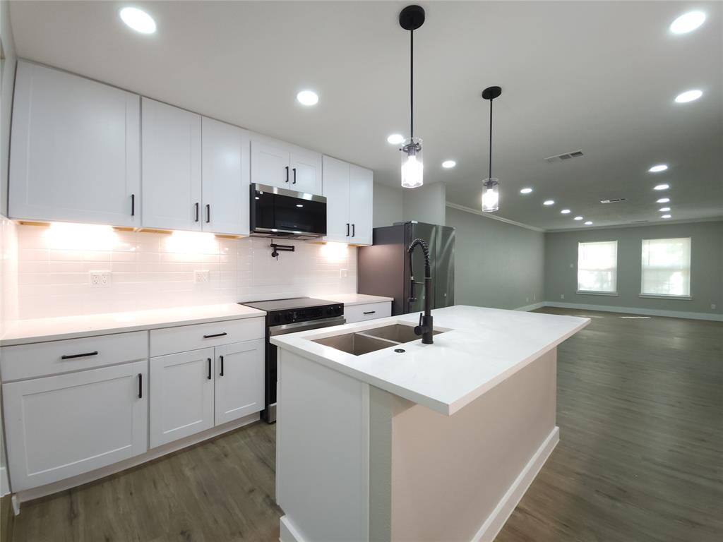 7039 Bates Street Dallas, TX 75227 - Photo 10 of 40 a kitchen with a sink stove and microwave