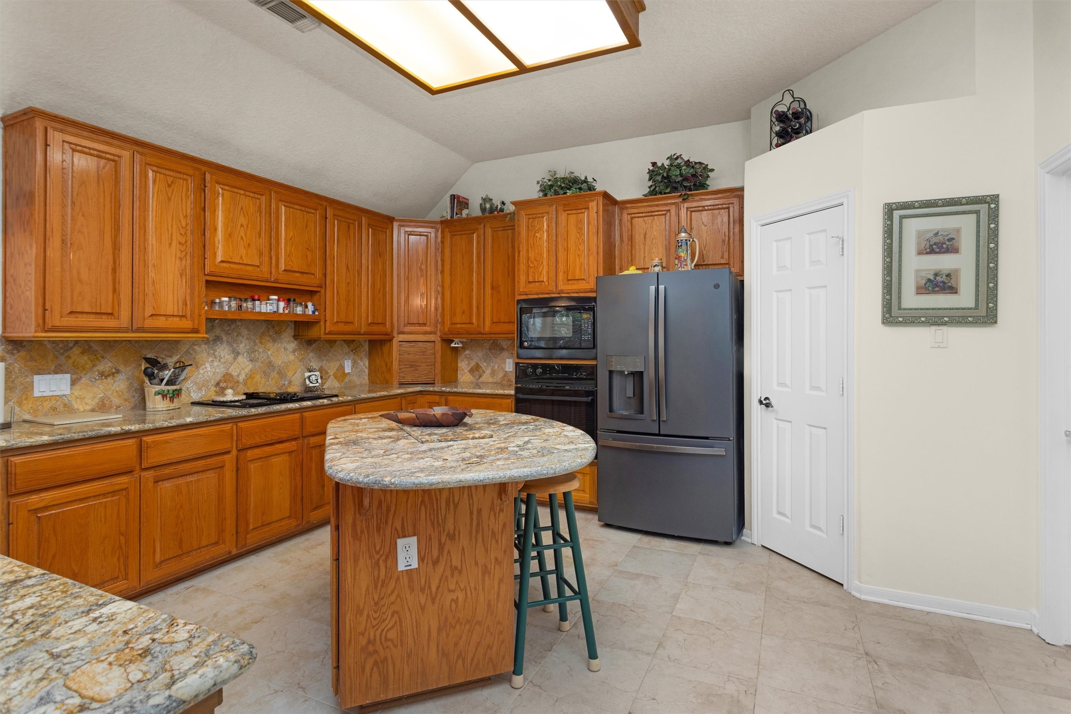 529 Stephen F Austin Drive Conroe, TX 77302 - Photo 19 of 37 a kitchen with stainless steel appliances granite countertop a refrigerator sink and cabinets