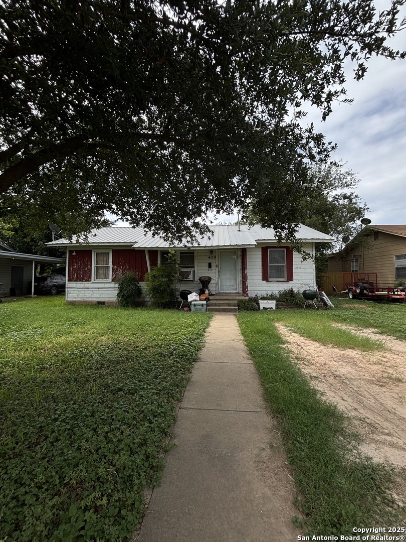a front view of a house with a yard and trees
