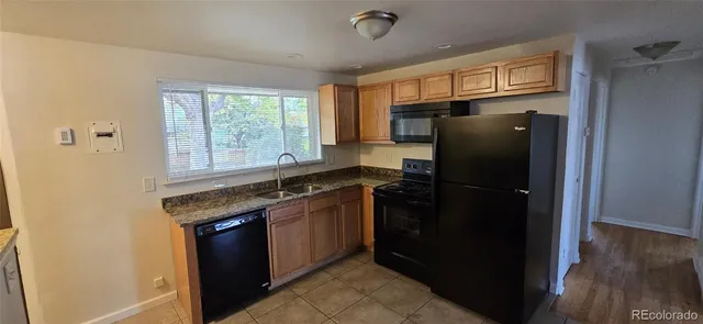 a kitchen with granite countertop a refrigerator and a sink