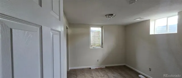 a view of a room that has wooden floor and window
