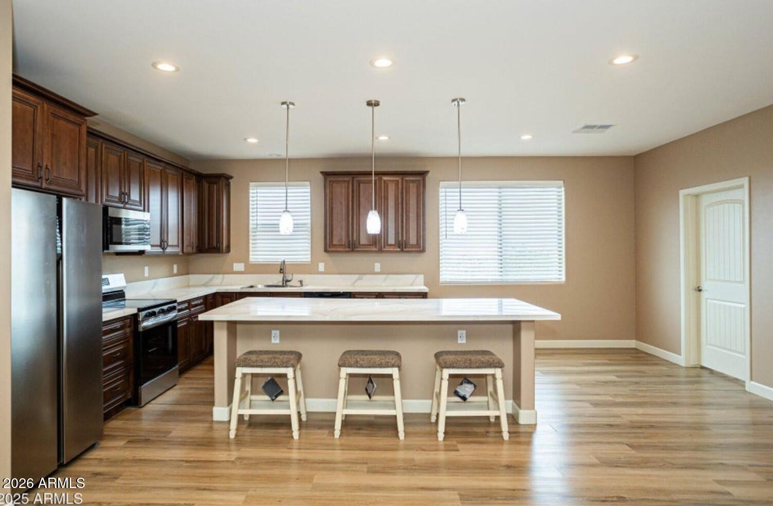4695 Kerry Drive Rimrock, AZ 86335 - Photo 19 of 47 a kitchen with granite countertop a stove a sink a refrigerator wooden cabinets and wooden floor