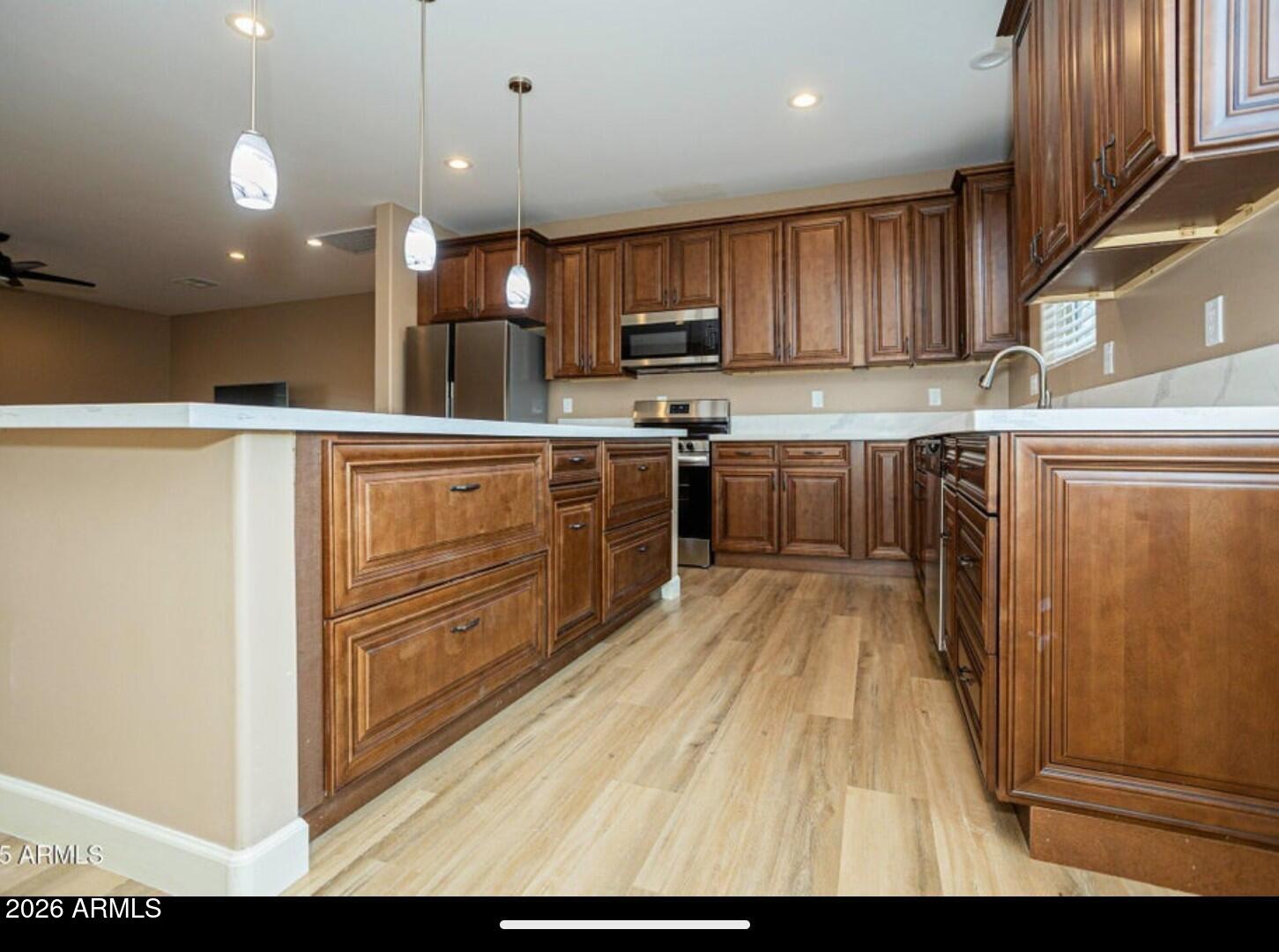 4695 Kerry Drive Rimrock, AZ 86335 - Photo 21 of 47 a kitchen with kitchen island granite countertop a refrigerator oven a sink dishwasher and wooden cabinets with wooden floor