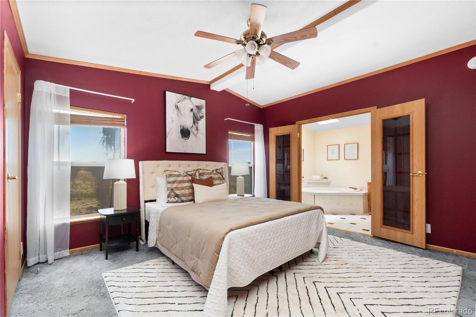 13201 Cavanaugh Road Hudson, CO 80642 - Photo 22 of 41 a bedroom with a large bed and a chandelier