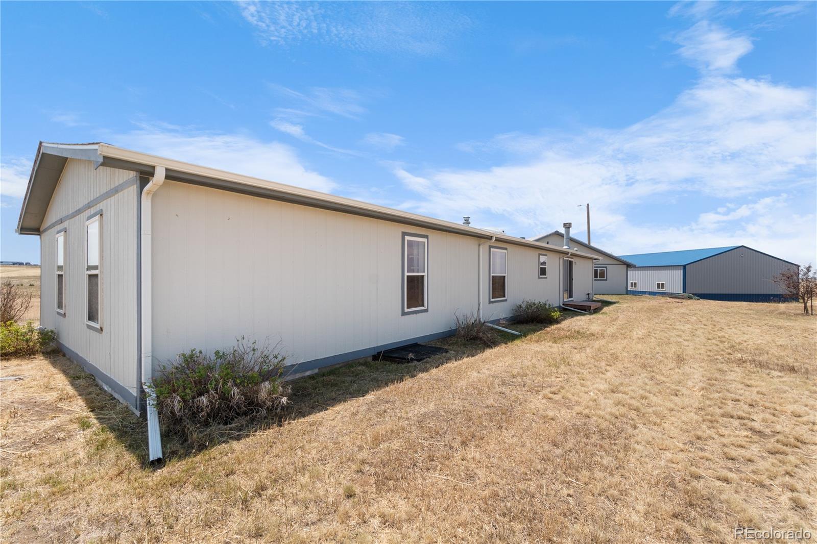 13201 Cavanaugh Road Hudson, CO 80642 - Photo 6 of 41 a backyard of a house with garage and yard