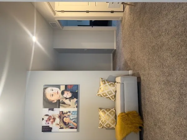 a bed with a white comforter and painting on the wall