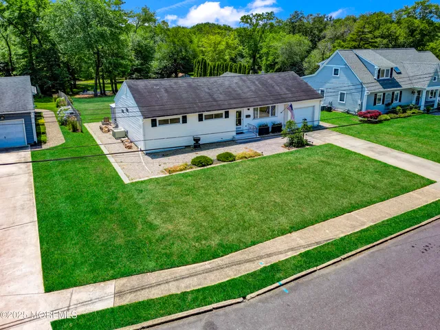 a view of house with garden and tall trees