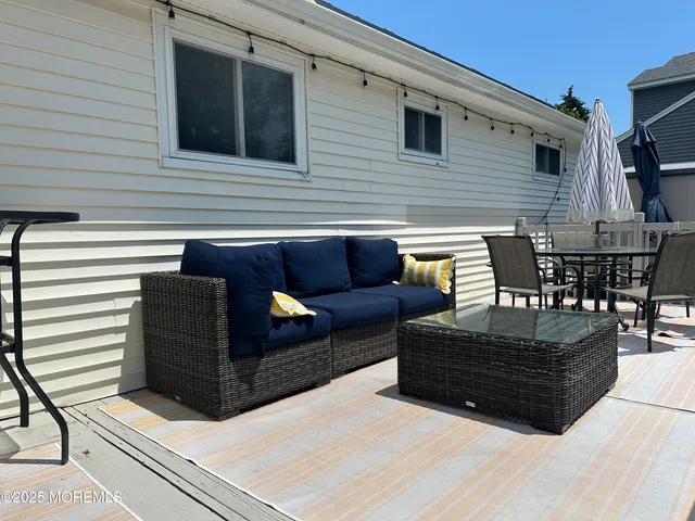 a view of a backyard with table and chairs potted plants and wooden fence