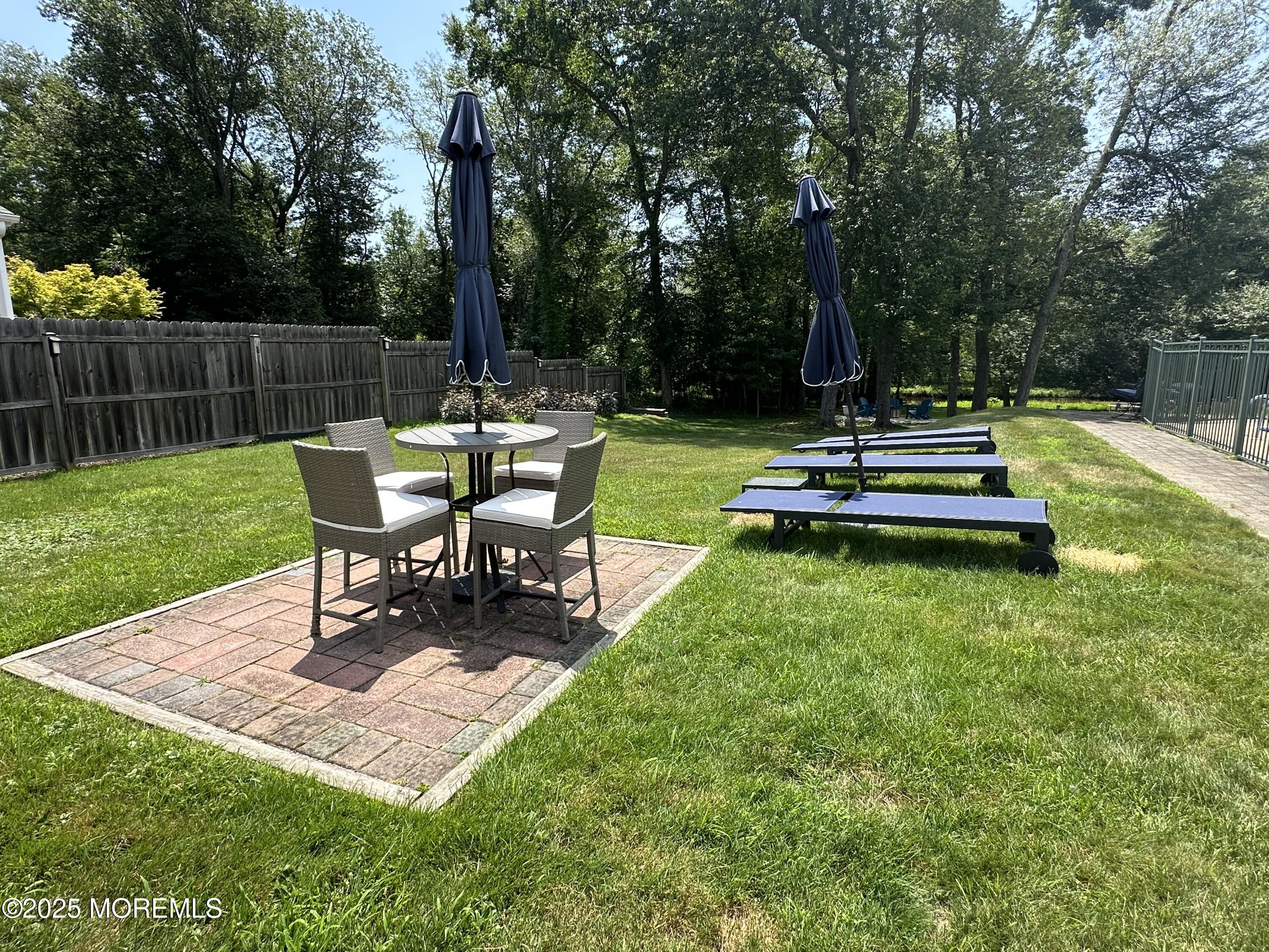 1007 Shore Road Spring Lake Heights, NJ 07762 - Photo 41 of 53 a view of a backyard with table and chairs potted plants and large tree