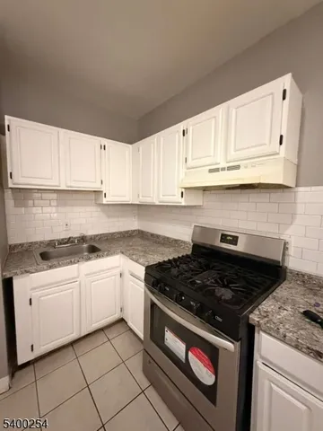 a kitchen with granite countertop white cabinets and white appliances