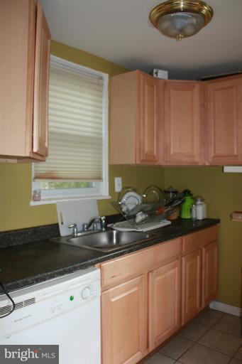 10141 Sutherland Road Silver Spring, MD 20901 - Photo 5 of 11 a kitchen with stainless steel appliances granite countertop a sink a stove and a wooden cabinets