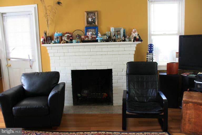 10141 Sutherland Road Silver Spring, MD 20901 - Photo 10 of 11 a living room with furniture a fireplace and a flat screen tv
