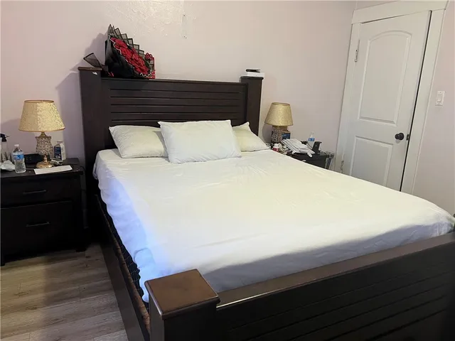 a bedroom with a bed and wooden floor