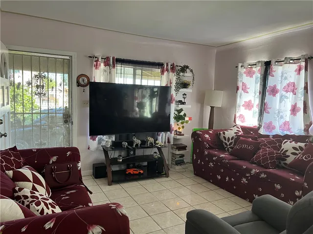 a living room with furniture a large window and a flat screen tv