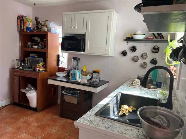 a kitchen with stainless steel appliances granite countertop a sink a stove and wooden cabinets