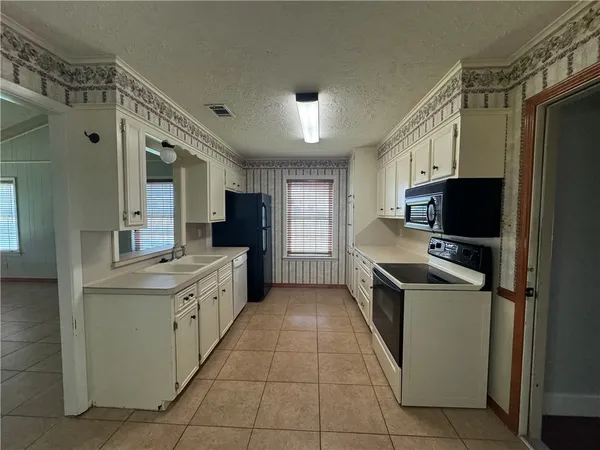 a kitchen with a stove sink and refrigerator