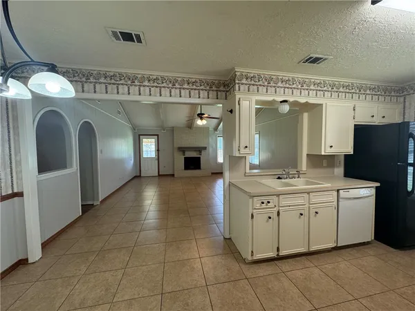 a view of a hallway with granite countertop a sink and a fireplace