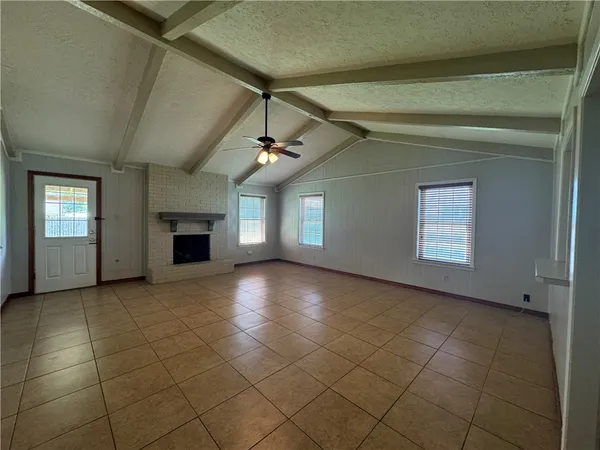 an empty room with windows and ceiling fan