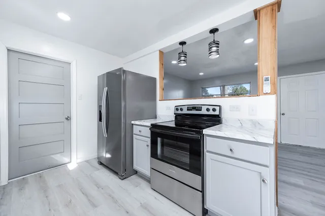 a kitchen with a stove refrigerator and microwave
