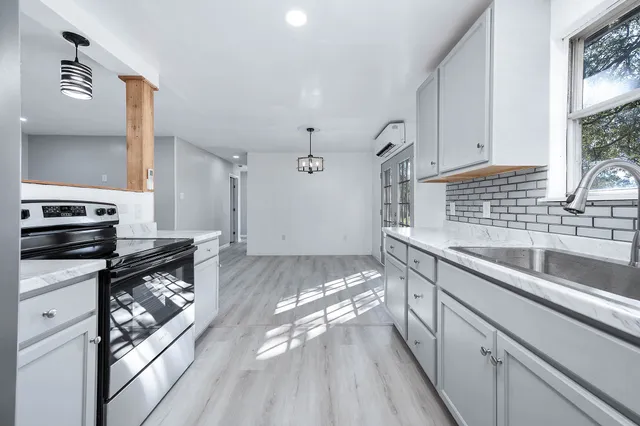 a kitchen with granite countertop a stove and a sink