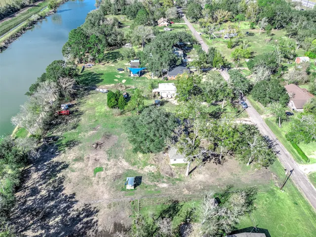 an aerial view of residential houses with outdoor space and trees