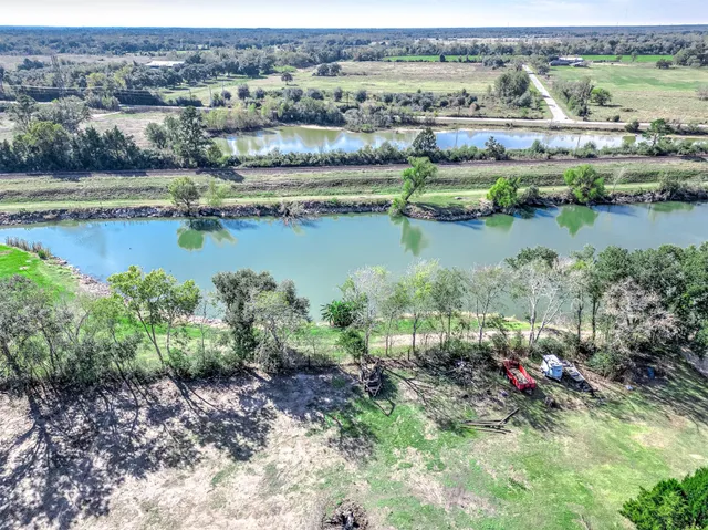 an aerial view of residential houses with outdoor space and lake view
