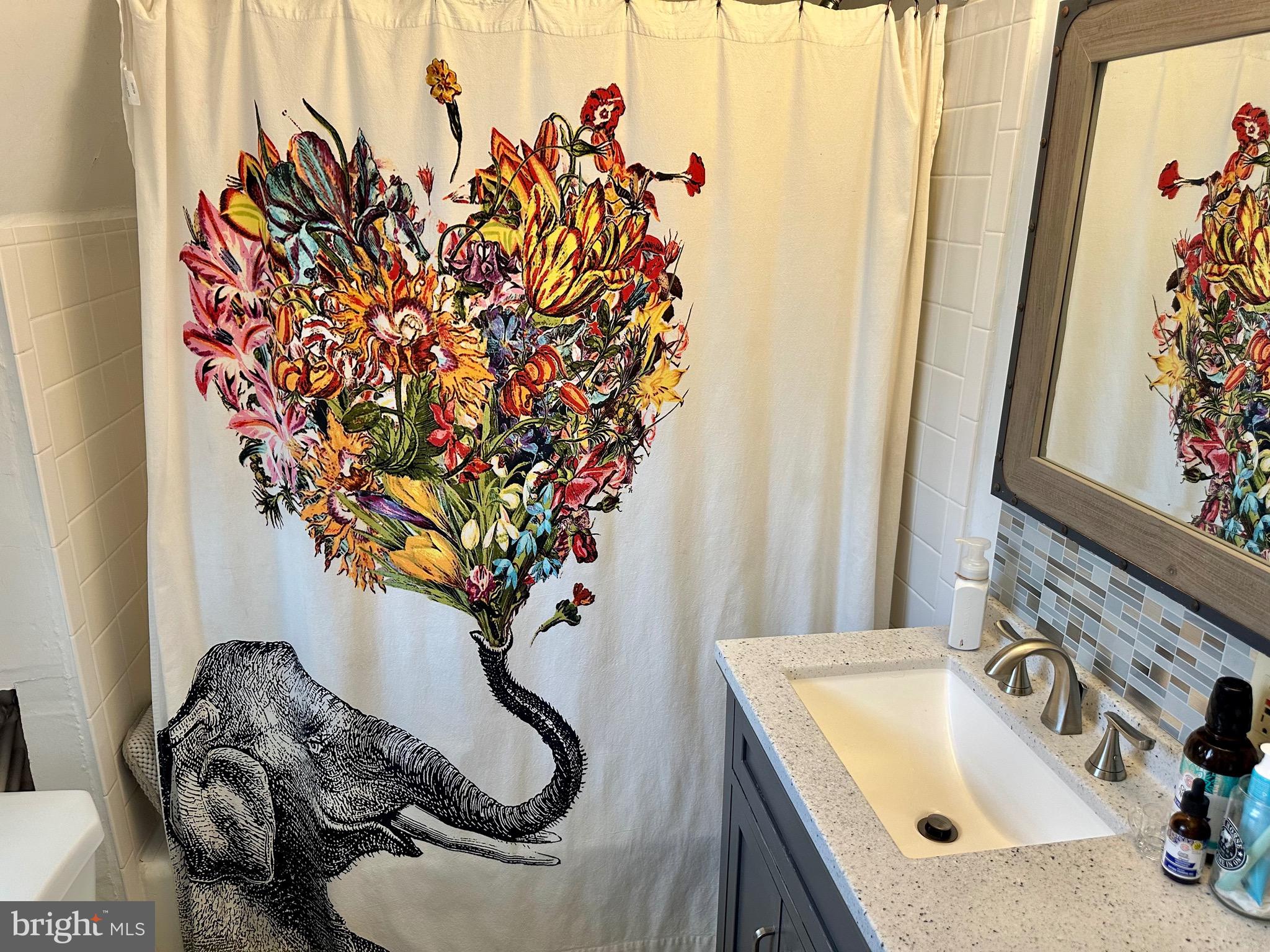1 West Street, Unit 414 Media, PA 19063 - Photo 12 of 20 a bathroom with a granite countertop sink and a blue curtain