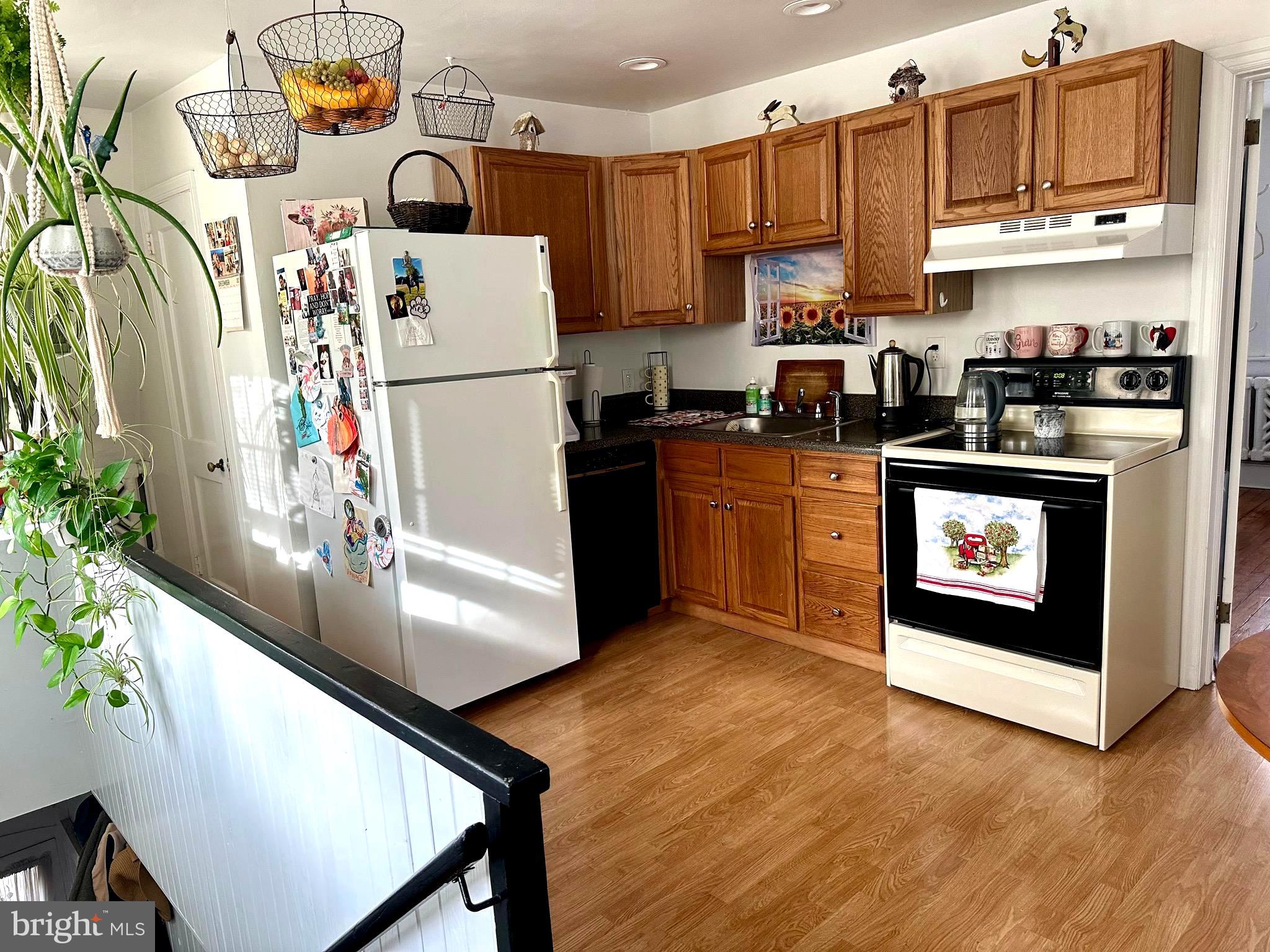 1 West Street, Unit 414 Media, PA 19063 - Photo 14 of 20 a kitchen with stainless steel appliances granite countertop a refrigerator a stove a sink and a microwave with wooden floor