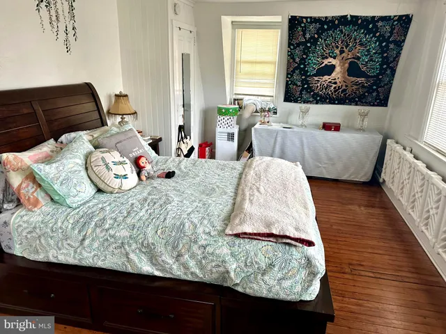 a bedroom with a bed and a flat tv screen on dresser