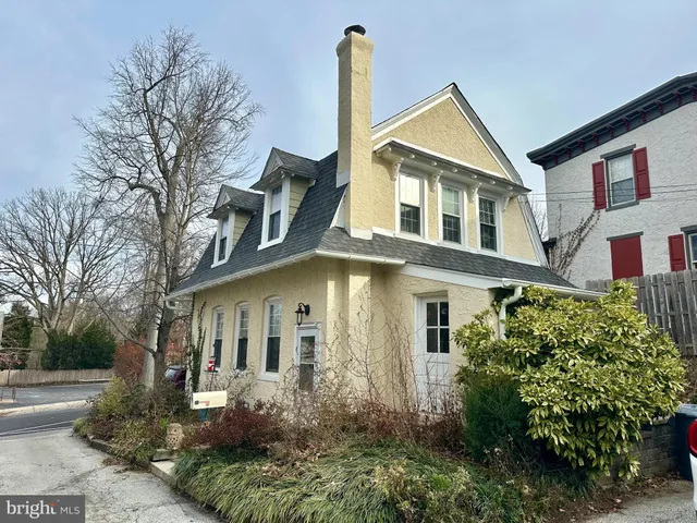 a view of a white house next to a yard