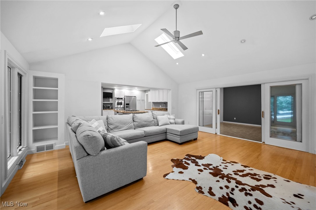 2711 Glenmont Road Northwest Canton, OH 44708 - Photo 18 of 42 Living room with a skylight, high vaulted ceiling, and light wood-style floors