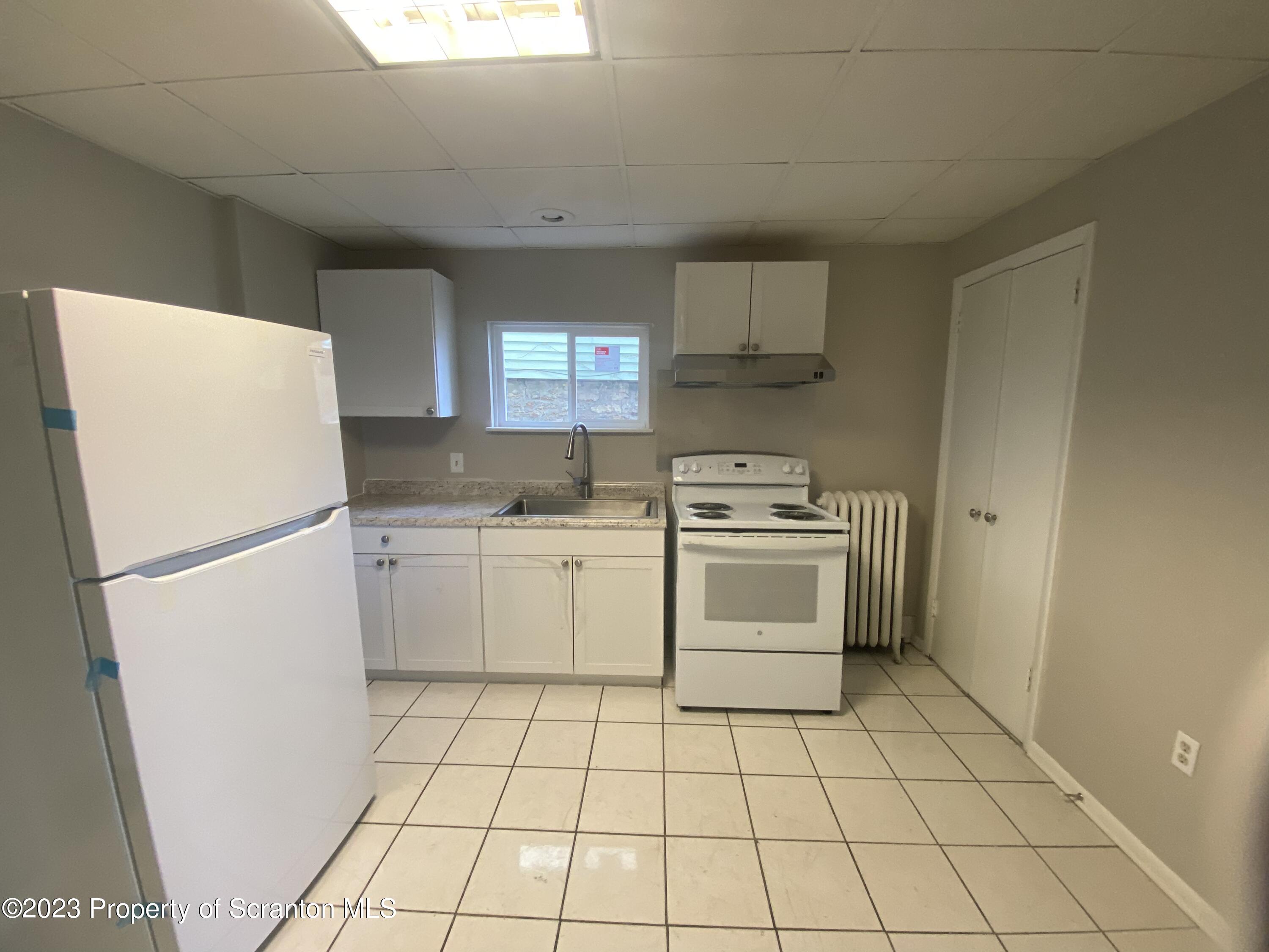 2513 North Main Avenue Scranton, PA 18508 - Photo 10 of 17 a kitchen with a stove a sink and a refrigerator
